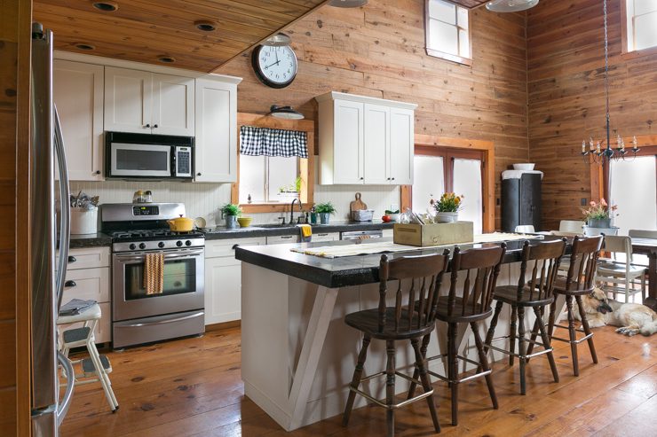Log Home Kitchen With White Cabinets, Beadboard, and Black Concrete Countertops 