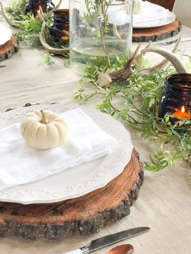 Rustic Natural Thanksgiving Table Using Deer Antlers, Greenery, Wood Slices, Mason Jars, and Natural Colors