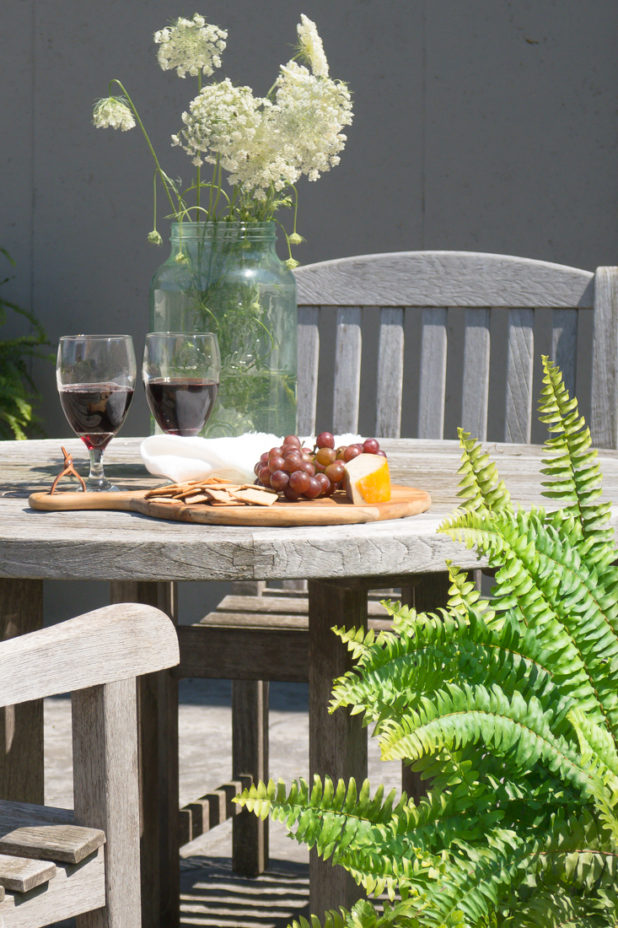 Outside Patio, Teak Furniture, Wildflowers, Straw Hat, Cheese Grapes and Cracker Board, Wine.